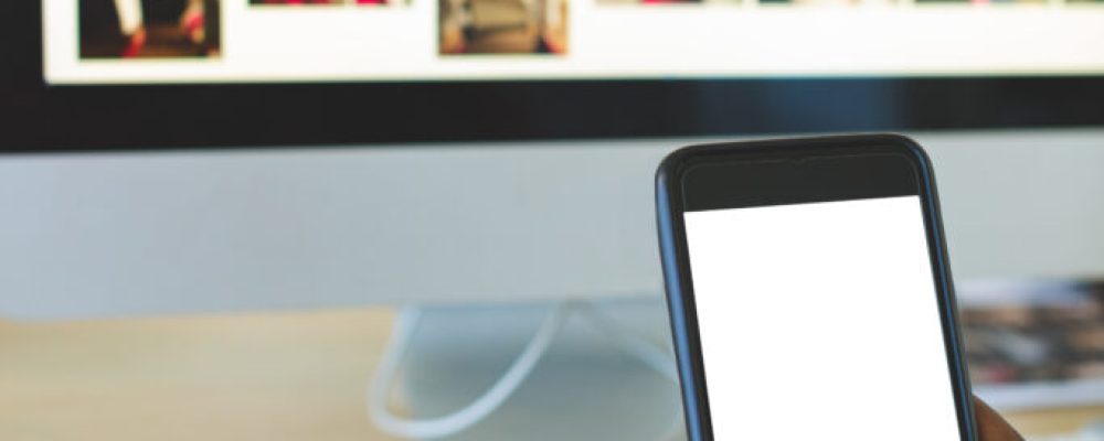 Close-up of young African-American businessman using mobile phone at desk in office